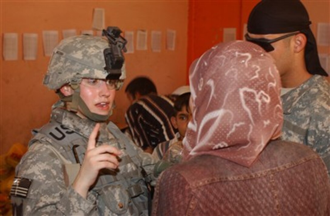 Army 1st Lt. Robyn Jacobs speaks with a woman.  Army 1st Lt. Robyn Jacobs (left) speaks with a woman on the security council during a humanitarian aid delivery at the Zafaraniyah Government Center in the Zafaraniyah area of East Baghdad, Iraq, on June 6, 2007. Jacobs is from Headquarters Company, 2nd Battalion, 17th Field Artillery Regiment, 2nd Brigade Combat Team, 2nd Infantry Division - Image DOD